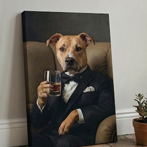 Puede incluir: Un lienzo impreso que muestra a un perro pitbull de color canela con el hocico blanco, vestido con esmoquin negro, camisa blanca y pajarita negra. El perro est&aacute; sentado en un sill&oacute;n de cuero beige y sostiene un vaso con l&iacute;quido &aacute;mbar.
