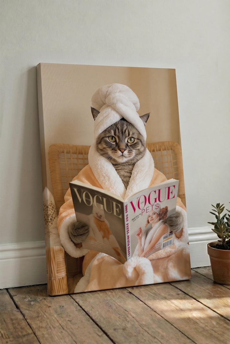Puede incluir: Un lienzo impreso que muestra a un gato atigrado con una toalla blanca envuelta en la cabeza y un albornoz de felpa color melocot&oacute;n. El gato est&aacute; sentado en una silla de mimbre y sostiene una revista abierta titulada Vogue Pets.
