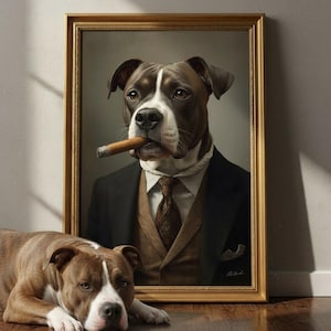 Puede incluir: Un retrato enmarcado de un perro marr&oacute;n y blanco con traje negro, chaleco marr&oacute;n y corbata estampada, sosteniendo un cigarro en la boca. Un perro marr&oacute;n y blanco con una mancha blanca en la cara yace en el suelo frente al marco dorado.