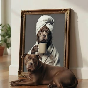 May include: A framed print featuring a brown dog in a white robe and towel, holding a mug. A second brown dog is lying on the floor in front of the framed print. The frame is ornate and gold-colored.