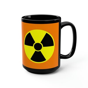 May include: Black coffee mug with a bright orange background and a yellow and black radiation symbol.