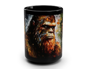 May include: Black ceramic coffee mug with a colorful illustration of Bigfoot, a mythical creature, with a serious expression. The background is a blurred forest scene.