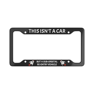 Puede incluir: Marco de matrícula negro con texto blanco que dice "Esto no es un coche. Sino un vehículo de reentrada suborbital." Dos cohetes rojos y blancos están a cada lado del texto.