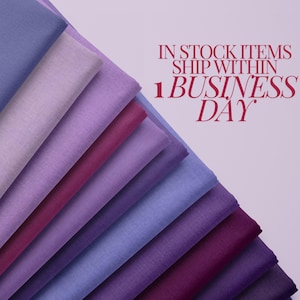 May include: A stack of fabric swatches in various shades of purple, blue, and pink. The fabric is smooth and has a subtle sheen.  The text "IN STOCK ITEMS SHIP WITHIN 1 BUSINESS DAY" is displayed above the fabric.