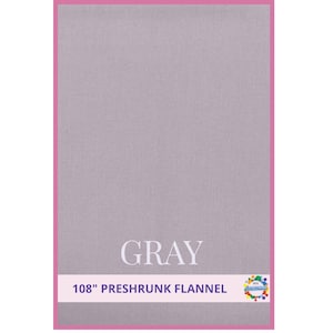 May include: A gray preshrunk flannel fabric with a pink border. The word "GRAY" is displayed in white, with the text "108" PRESHRUNK FLANNEL" below it. The fabric is 108 inches wide.