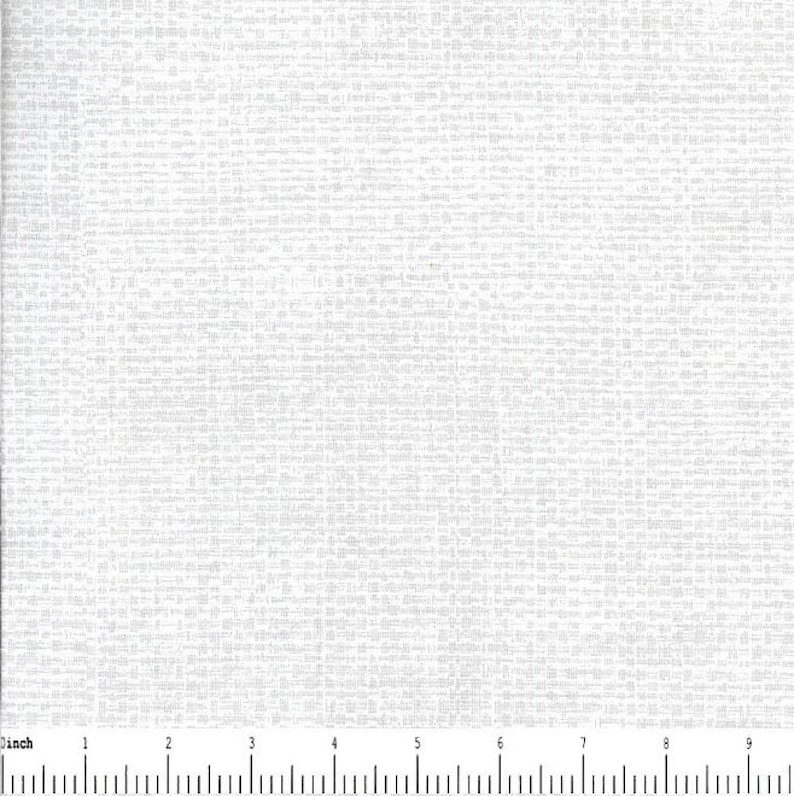 May include: A white fabric featuring a subtle, repeating grid pattern of small, light gray horizontal and vertical dashes. A black and white ruler is visible at the bottom, showing a scale of 9 inches across the width of the textile material.