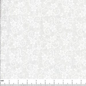 May include: A white fabric featuring a repeating pattern of light gray floral vines and leaves. A ruler is visible at the bottom edge, showing a scale in inches, with the fabric pattern extending across the full width of the frame.
