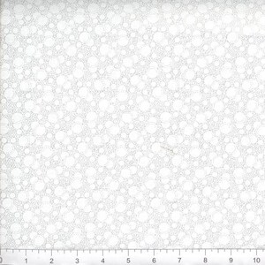 May include: A white fabric featuring a repeating pattern of light gray circles of varying sizes. A ruler is visible at the bottom edge, showing a scale of 10 inches, with each numbered increment representing one inch of the fabric's width.