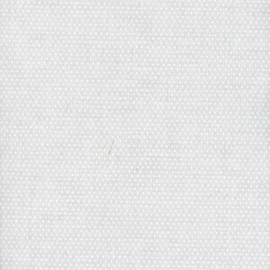 May include: A light gray fabric featuring a repeating pattern of tiny white polka dots arranged in a uniform grid. The textile surface displays a subtle woven texture with a consistent matte finish across the entire visible area of the material.