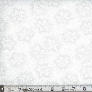 May include: A white fabric featuring a repeating pattern of light gray floral outlines surrounded by fine stippled dots. A Dritz measuring tape is positioned at the bottom, showing a scale of 8 inches across the width of the textile material.