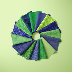 May include: A collection of 15 fabric squares in shades of green and blue with various patterns. The squares are arranged in a circle.