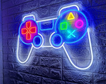 May include: A neon sign shaped like a video game controller with colorful buttons. The sign is mounted on a white brick wall.