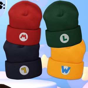 Puede incluir: Un conjunto de seis gorros de punto de diferentes colores, cada uno con un personaje diferente de la franquicia Super Mario Bros. Los gorros son rojo, verde, azul marino, amarillo, negro y marrón. Cada gorro tiene la inicial de un personaje diferente bordada en la parte delantera. El texto "SUPER-STAR COSPLAY" es visible en la esquina inferior derecha de la imagen.