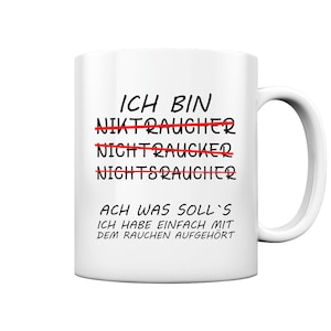 Könnte beinhalten: Weisse Keramiktasse mit schwarzem Text, der "ICH BIN" lautet, wobei die Wörter "NIKTRAUCHER", "NICHTRAUCKER" und "NICHTSRAUCHER" durchgestrichen sind. Der Text setzt sich fort mit "ACH WAS SOLL'S ICH HABE EINFACH MIT DEM RAUCHEN AUFGEHÖRT".