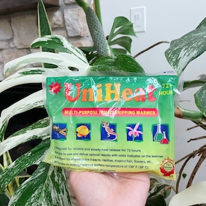 May include: A green and yellow UniHeat multi-purpose jumbo shipping warmer with a 72-hour heat release. The warmer features a color indicator and is designed for shipping live insects, reptiles, tropical fish, flowers, and other items. It provides an average warmer surface temperature of 100°F (38°C).