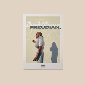 May include: A poster featuring the text "Daniel Caesar FREUDIAN," with a person in profile, holding a cigarette. The background is a light beige with abstract white lines. A shadow of the person is visible. The poster has a white border.
