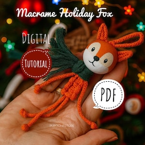 Pode incluir: Enfeite de raposa em macramé feito à mão com detalhes em laranja e verde. A raposa tem um rosto branco, orelhas laranja e um cachecol verde. A imagem inclui o texto "Macrame Holiday Fox", "Digital Tutorial" e "PDF."