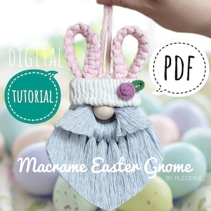 May include: A digital PDF tutorial for making a macrame Easter gnome with pink bunny ears, a white crocheted hat, a wooden bead nose, and a light blue beard. The gnome is sitting on a bed of pastel colored Easter eggs.