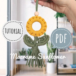 May include: A yellow and green macrame sunflower with a wooden bead at the top. The sunflower is hanging from a green cord. The image includes the text "DIGITAL PDF TUTORIAL BY PLECIONE Macrame Sunflower".