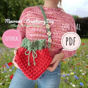 Pode incluir: Uma bolsa de crochê vermelha e verde em forma de morango com fecho de cordão. A bolsa está sendo segurada por uma pessoa que está vestindo um suéter rosa e jeans azul. A bolsa tem uma alça de corrente de margaridas brancas. A imagem inclui o texto "Macrame Strawberry Bag", "DIGITAL", "PDF", e "TUTORIAL".