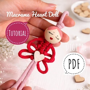 Könnte beinhalten: Handgemachte Makramee-Herzpuppe mit einem Holzkopf und einem herzförmigen roten Körper. Die Puppe hat rosa Haare und ein Herz aus Holz. Der Text "Macrame Heart Doll" und "Tutorial" sind sichtbar.