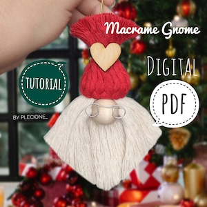 May include: A red and white macrame gnome ornament with a wooden heart and glasses. The ornament is hanging from a string and has a green speech bubble with the word "TUTORIAL" in it. The text "Macrame Gnome DIGITAL PDF" is also visible in the image.
