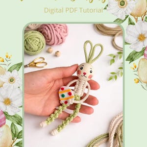 May include: A macrame bunny doll with green and cream detailing, holding a decorative Easter egg. The doll has a wooden head and is part of a digital PDF tutorial. The background includes yarn, scissors, and floral decorations.