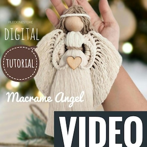Op de afbeelding: Een wit macramé engel ornament met een houten hoofd en hart. De engel hangt aan een touwtje en wordt in een hand gehouden. De tekst "DIGITALE TUTORIAL" en "Macramé Engel VIDEO" is zichtbaar in de afbeelding.