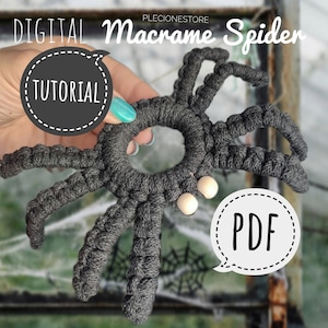 Puede incluir: Una araña de macramé gris con cuentas de madera blancas para los ojos. La araña está siendo sostenida por una mano. El texto "DIGITAL Macrame Spider TUTORIAL PDF" está en la imagen.