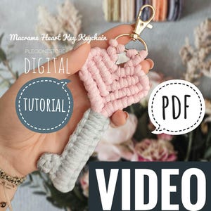 Könnte beinhalten: Ein rosa-grauer Makramee-Herz-Schlüsselanhänger mit einem goldenen Schlüsselring. Der Schlüsselanhänger ist mit "Macrame Heart Key Keychain" und "DIGITAL TUTORIAL" in einer Sprechblase beschriftet. Das Bild enthält auch eine Sprechblase mit der Aufschrift "PDF VIDEO".