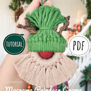May include: A green and beige macrame reindeer gnome ornament with a red nose and brown antlers. The ornament is hanging from a gold string. The text "DIGITAL TUTORIAL" and "PDF" are visible in the image.