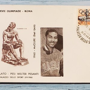 May include: Vintage postcard from the 1960 Rome Olympics. Features a stamp with Olympic rings and a track, a portrait of an athlete, and a seated statue. Text includes "XVII OLIMPIADE - ROMA" and "PUGILATO - PESI WELTER PESANTI".
