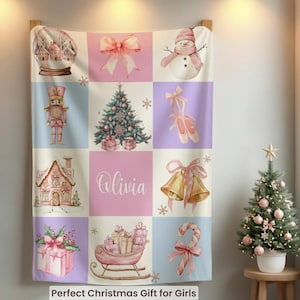 May include: A Christmas-themed blanket with a grid pattern featuring festive illustrations. The design includes a snow globe, a snowman, a Christmas tree, and a gingerbread house. The name "Olivia" is displayed in the center. The blanket is a soft, cozy gift.