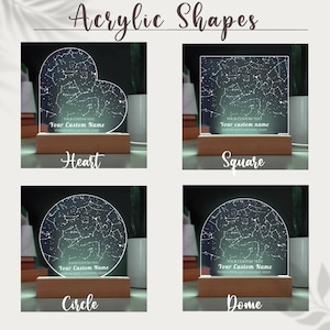 May include: Acrylic shapes with a constellation design, available in heart, square, circle, and dome shapes. Each shape has a wooden base and features customizable text: "Your Custom Name" and "Custom Date, Location, State".