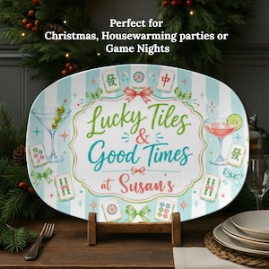 May include: An oval serving platter with a light blue and white striped background, featuring illustrations of mahjong tiles, martini glasses, and green bows. The center text reads Lucky Tiles & Good Times at Susan's in green, blue, and red script.