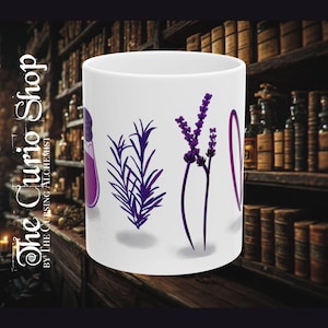 May include: A white ceramic mug featuring a purple graphic design. The print displays a purple potion bottle, a sprig of rosemary, a stalk of lavender, and a purple heart outline. The mug has a smooth, cylindrical body and a plain white handle.