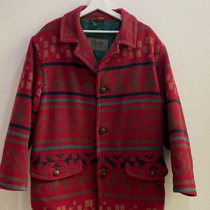 May include: A red jacket with a dark green and brown geometric pattern, featuring a collar, long sleeves, four front buttons, and two flap pockets. The interior lining is dark green, and a label reads Stones Casual at the neckline.