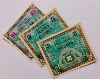 Könnte beinhalten: Drei alte französische Banknoten. Die Scheine sind in Grüntönen gehalten und tragen den Text "EMIS EN FRANCE" sowie die Stückelung in großen Zahlen. Die Scheine sind für 2, 5 und 10 Francs.