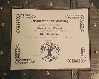 Peut inclure: Un certificat de handfasting avec une bordure de nœud celtique et un motif d'arbre de vie. Le texte indique : "Ceci certifie que (Nom 1) & (Nom 2) se sont engagés l'un envers l'autre par le rite du handfasting, s'unissant en tant que partenaires dans l'amour et la vie le (Date)"
