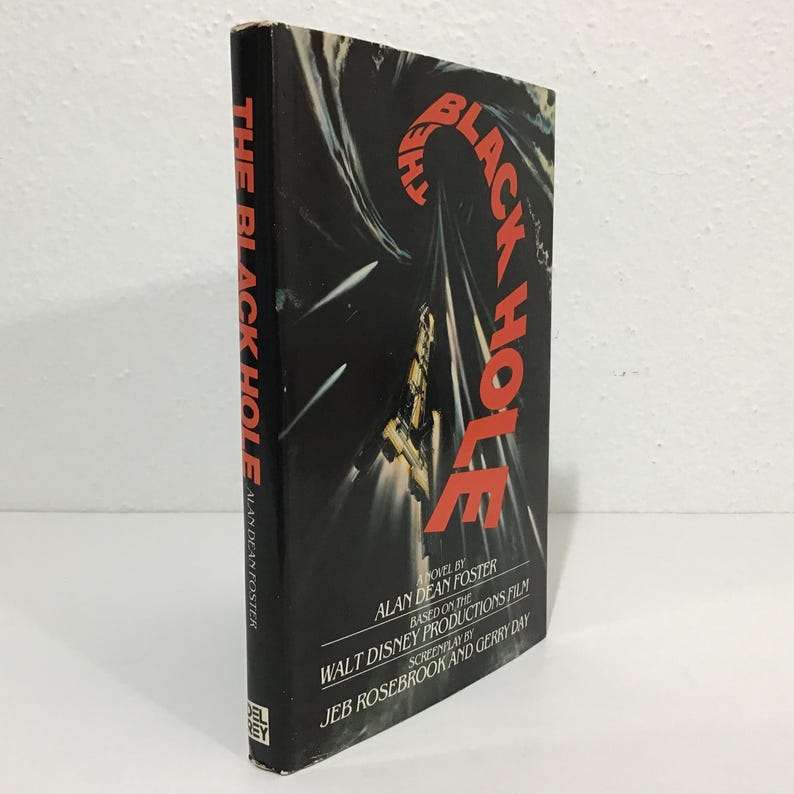 Op de afbeelding: Een hardcover boek met de titel "The Black Hole" van Alan Dean Foster. De zwarte omslag toont de rode titel en een illustratie van een ruimteschip. Gebaseerd op de Walt Disney Productions film.