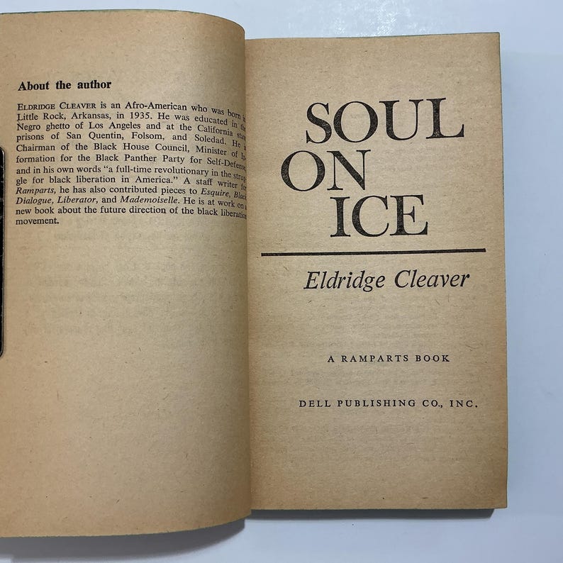 Puede incluir: Las p&aacute;ginas abiertas del libro Soul on Ice de Eldridge Cleaver, publicado por Dell Publishing Co., Inc. La p&aacute;gina izquierda presenta una secci&oacute;n sobre el autor, mientras que la p&aacute;gina derecha muestra el t&iacute;tulo, el nombre y la editorial en negro.