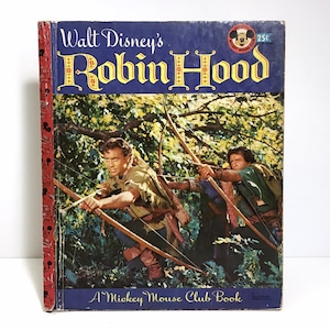 May include: A vintage Walt Disney's Robin Hood Mickey Mouse Club book with a cover image of two men in green outfits with bows and arrows in a forest setting. The book is red and blue with a Mickey Mouse head logo and the text "25c".