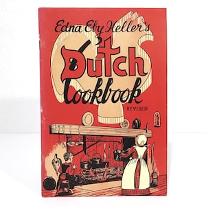 May include: A vintage cookbook titled "Edna Eby Heller's 31 Dutch Cookbook" with a red cover. The cover features a stylized illustration of a Dutch kitchen scene with a fireplace and figures. The title is in a bold, decorative font.
