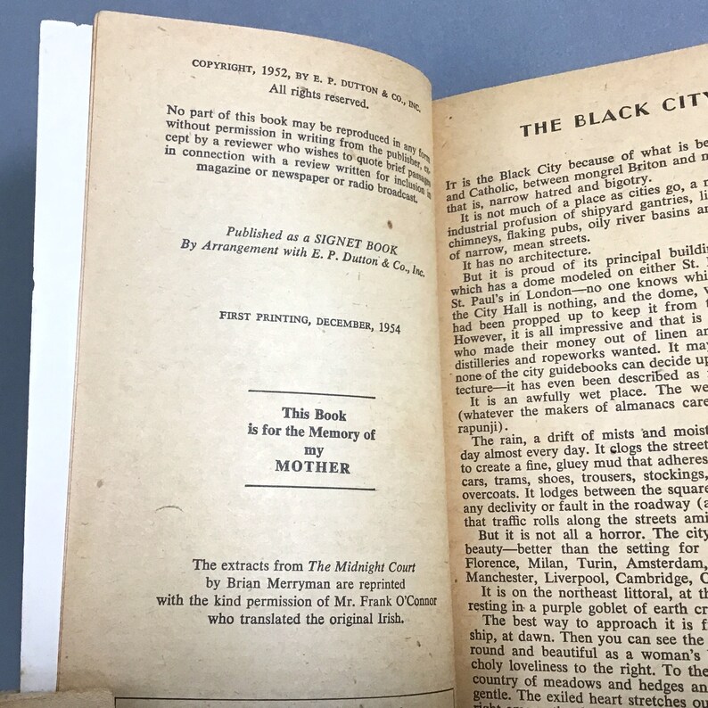 K&ouml;nnte beinhalten: Ein Vintage-Buch mit einem schwarzen und wei&szlig;en Einband. Der Titel des Buches lautet "The Black City". Das Buch handelt von der Stadt Liverpool in England. Das Buch wurde von E.P. Dutton & Co., Inc. ver&ouml;ffentlicht und wurde erstmals im Dezember 1954 gedruckt.
