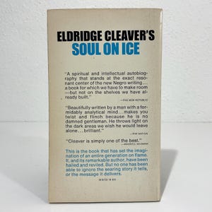 Puede incluir: La contraportada del libro Soul on Ice de Eldridge Cleaver, con texto en negro y azul sobre un fondo crema. Incluye rese&ntilde;as impresas de The New Republic, The Nation y Maxwell Geismar, junto con el texto Printed in USA.