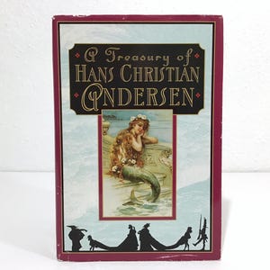 May include: A hardcover book titled "A Treasury of Hans Christian Andersen." The cover features a mermaid illustration and decorative text. The book has a burgundy border and a light blue background.