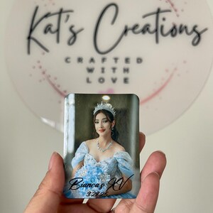 Puede incluir: Un im&aacute;n fotogr&aacute;fico rectangular con una mujer con un vestido azul claro, tiara y collar. El texto "Bianca's XV 3.29.25" est&aacute; escrito en el im&aacute;n. El fondo incluye un logotipo que dice "Kat's Creations".