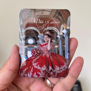Puede incluir: Impresi&oacute;n fotogr&aacute;fica rectangular de una joven con un vestido de baile rojo con detalles de encaje blanco. La impresi&oacute;n incluye el texto "Mis 15 a&ntilde;os Sofia", conmemorando una celebraci&oacute;n de quincea&ntilde;era.