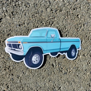 Peut inclure: Un camion pick-up bleu clair avec une bande noire et un pare-chocs noir. Le camion a un intérieur blanc et un volant noir.