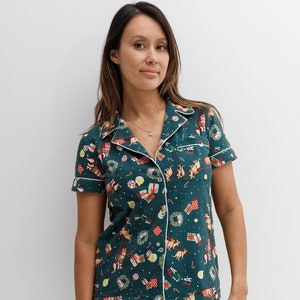 May include: A green and red pajama set with a Christmas-themed print featuring kangaroos, presents, and candy canes. The set includes a short-sleeved shirt with a collared neckline and matching shorts.